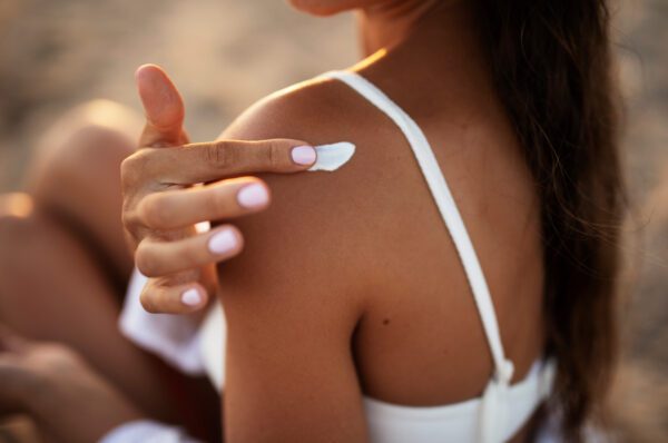 Close up of woman applying sunscreen to her shoulder